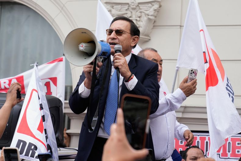 El expresidente Martín Vizcarra, quien enfrenta cargos de corrupción, habla con sus seguidores afuera del tribunal donde está siendo juzgado, en Lima, Perú, el jueves 20 de noviembre de 2025. (AP Foto/Martín Mejía)