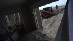 Scott Bennett, un contratista que se especializa en recuperación tras el paso de tormentas, quita arena del patio de un condominio playero en Venice, Florida, tras el paso del huracán Milton, el sábado 12 de octubre de 2024. (AP Foto/Rebecca Blackwell)