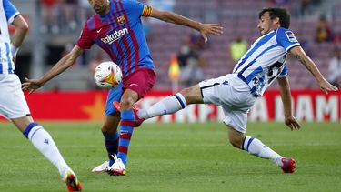 ARCHIVO - David Silva (derecha) de la Real Sociedad pugna por el balón con Sergio Busquets del Barcelona en un partido de la Liga de España, el domingo 15 de agosto de 2021. (AP Foto/Joan Monfort)