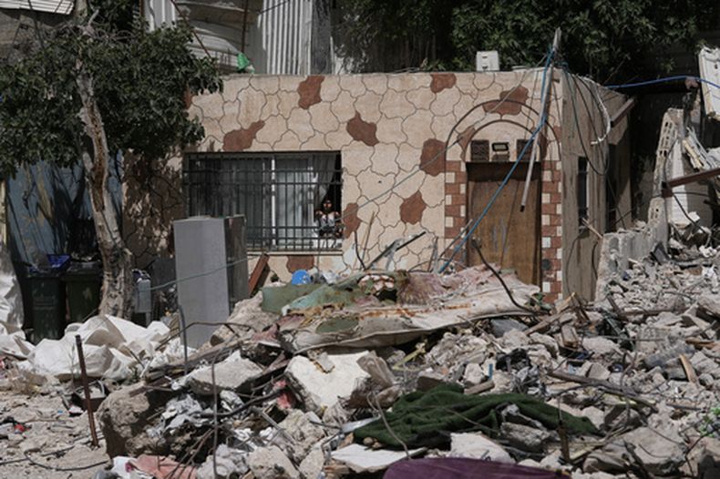 Una niña palestina mira por la ventana a los escombros de una casa derribada pro autoridades israelíes en el vecindario de Silwan, en Jerusalén Oriental, el 19 de mayo de 2026. (AP Foto/Mahmoud Illean)