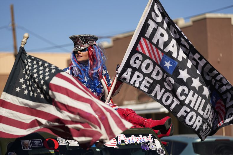 Micki Larson-Olson sostiene una bandera cerca del sitio donde el gobernador de Texas, Greg Abbott, y otros gobernadores republicanos se reunieron junto al río Bravo (o Grande) en la frontera entre Estados Unidos y México, el domingo 4 de febrero de 2024, en Eagle Pass, Texas. (AP Foto/Eric Gay)