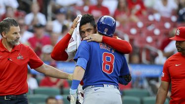 El venezolano Willson Contreras, de los Cardenales de San Luis, abraza a Ian Happ, de los Cachorros de Chicago, quien lo golpeó con el movimiento de su bate en el juego del jueves 27 de julio de 2023 (AP Foto/Scott Kane)