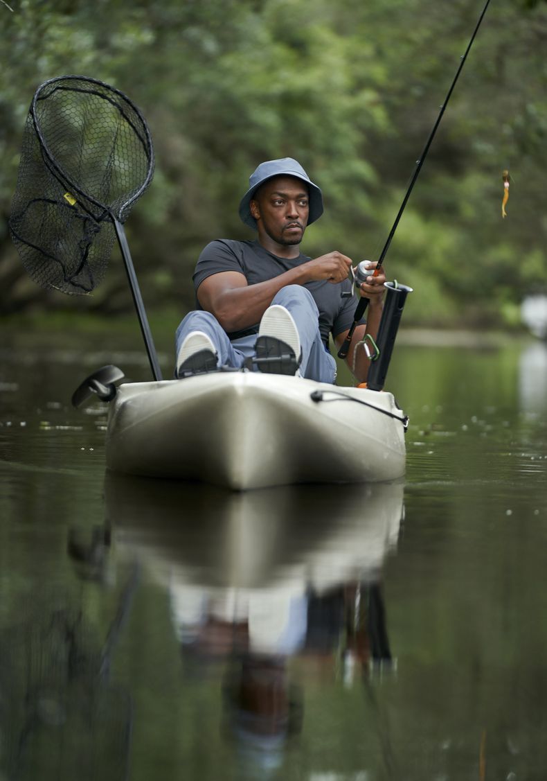 En esta imagen proporcionada por National Geographic, el actor y presentador Anthony Mackie pesca desde su kayak en los pantanos cerca de Violet, Luisiana, durante el rodaje de Shark Beach with Anthony Mackie. (Brian Roedel/National Geographic via AP)