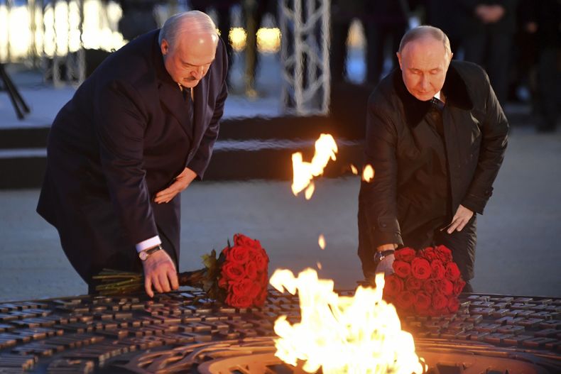 El presidente ruso Vladímir Putin, a la derecha, y el presidente bielorruso Alexander Lukashenko depositan flores mientras asisten a la ceremonia de inauguración del complejo conmemorativo A los ciudadanos pacíficos de la Unión Soviética que murieron durante la Gran Guerra Patria, la Segunda Guerra Mundial, cerca del pueblo de Zaitsevo en la región de Leningrado, Rusia, sábado 27 de enero de 2024. (Olga Maltseva/Pool Foto via AP)