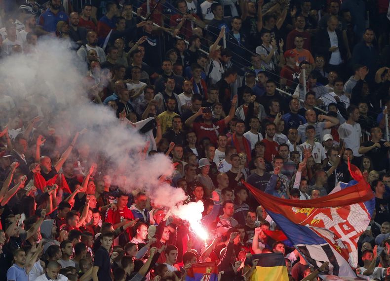 Aficionados serbios reaccionan durante el partido entre Serbia y Albania por el Grupo I de eliminatorias Euro 2016, en el Estadio Partizan en Belgrado, Serbia, 14 de octubre de 2014. El partido fue suspendido despu&eacute;s de las peleas en el campo entre