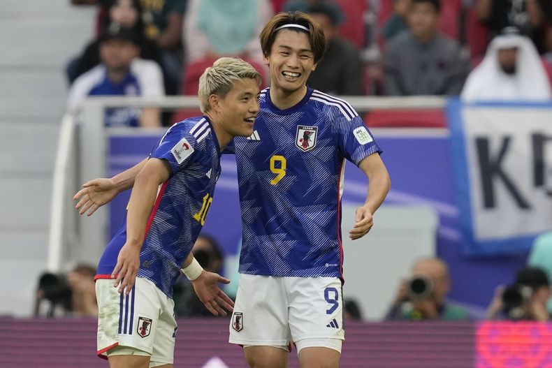 Ayase Ueda (derecha) celebra con Ritsu Doan tras anotar el tercer gol de Japón en la victoria 3-1 ante Bahréin en los octavos de final de la Copa Asia, el miércoles 31 de enero de 2024. (AP Foto/Thanassis Stavrakis)