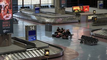 Personas esperan en la zona de entrega de equipaje del Aeropuerto Internacional Harry Reid, el viernes 29 de agosto de 2025, en Las Vegas. (AP Foto/John Locher)