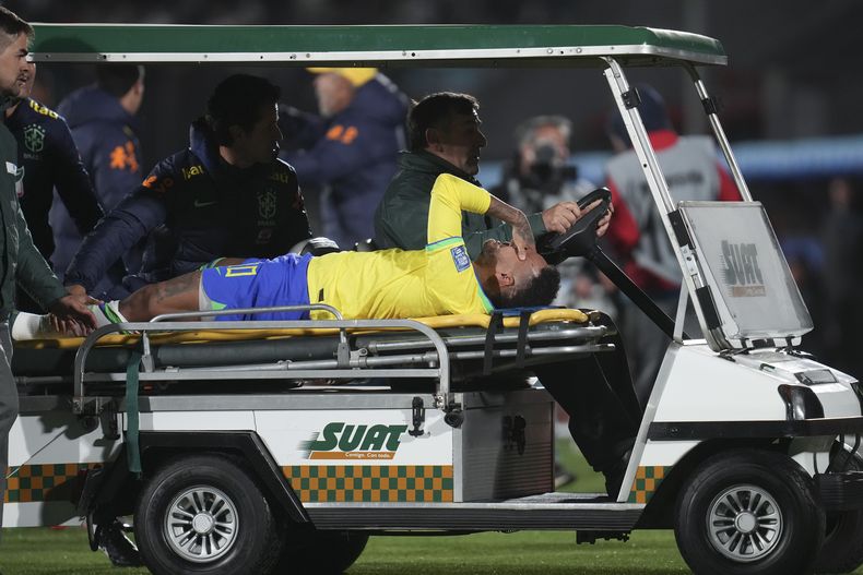 El delantero brasileño Neymar es transportado en camilla después de sufrir una lesión en partido de clasificación para la Copa del Mundo de 2026 en contra de Uruguay en el estadio Centenario, en Montevideo, Uruguay, el martes 17 de octubre de 2023. (AP Foto/Matilde Campodonico)