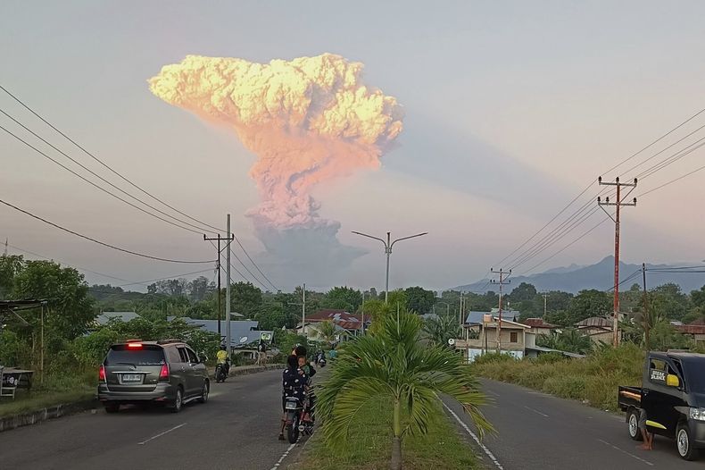 Gente mira mientras el monte Lewotobi Laki-Laki expulsa material volcánico durante una erupción en Maumere, Indonesia, el martes 17 de junio de 2025. (AP Foto)