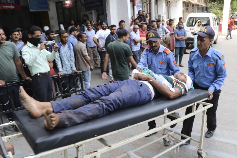 Un hombre que resultó herido luego de que un autobús cayera a un barranco es trasladado a un hospital en Jammu, India, el jueves 30 de mayo de 2024. (AP Foto)