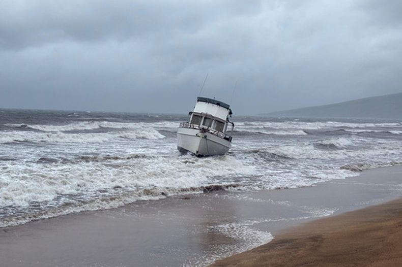 En esta foto proporcionada por el condado Maui, un barco está encallado en una playa frente a Kihei, Hawai, durante una fuerte lluvia el viernes 13 de marzo de 2026. (Condado Maui vía AP)
