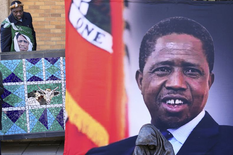 ARCHIVO - Un simpatizante llega a una misa en honor del expresidente de Zambia Edgar Lungu, que aparece en una pancarta a la derecha, en la Catedral de Cristo Rey en Johannesburgo, Sudáfrica, el 25 de junio de 2025. (AP Foto/Themba Hadebe), archivo)