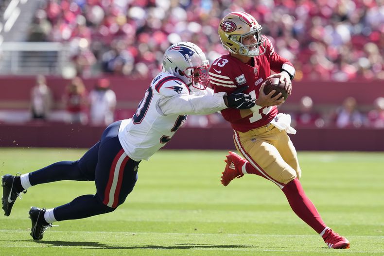 El quarterback de los 49ers de San Francisco Brock Purdy corre con el balón mientras lo intenta capturar el linebacker de los Patriots de Nueva Inglaterra Raekwon McMillan el domingo 29 de septiembre del 2024. (AP Foto/Godofredo A. Vásquez)