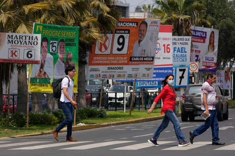 Peatones pasan junto a carteles de campaña electoral de candidatos presidenciales y congresistas, antes de las elecciones del fin de semana en Lima, Perú, el viernes 10 de abril de 2026. (Foto AP/Martín Mejía)