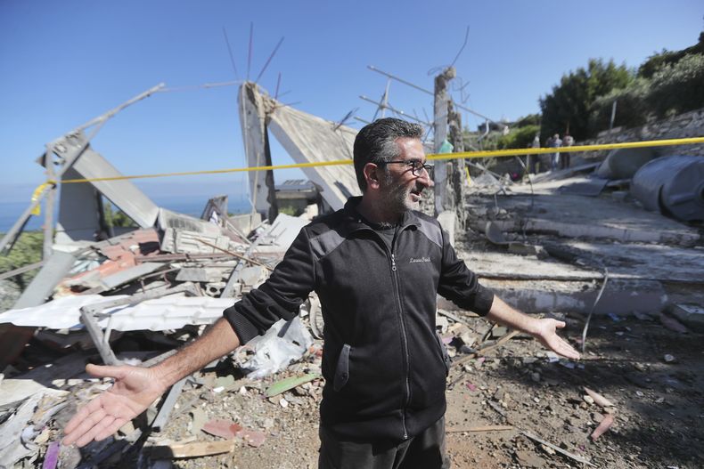 Un libanés hace señas mientras inspecciona una casa destruida, alcanzada la noche del viernes por un ataque aéreo israelí que provocó la muerte de una mujer e hirió a varias personas, en el poblado sureño de Adloun, Líbano, el sábado 1 de junio de 2024. (AP Foto/Mohammad Zaatari)