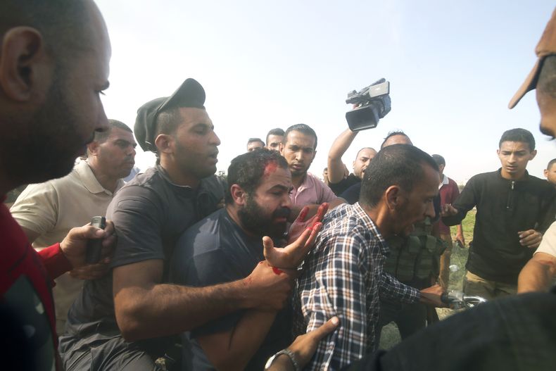 Palestinos llevan a un ciudadano israelí capturado (centro), desde el kibutz de Kfar Azza a la Franja de Gaza, el 7 de octubre de 2023. Hamás, el grupo insurgente que gobierna la Franja de Gaza, llegó a cabo un ataque sin precedentes y por varios frente sobre Israel al amanecer del 7 de octubre, disparando miles de proyectiles mientras docenas de combatientes cruzaban la fortificada frontera para infiltrarse en varias localidades por tierra, mar y aire, tomando al país por sorpresa durante un importante feriado. (AP Foto)