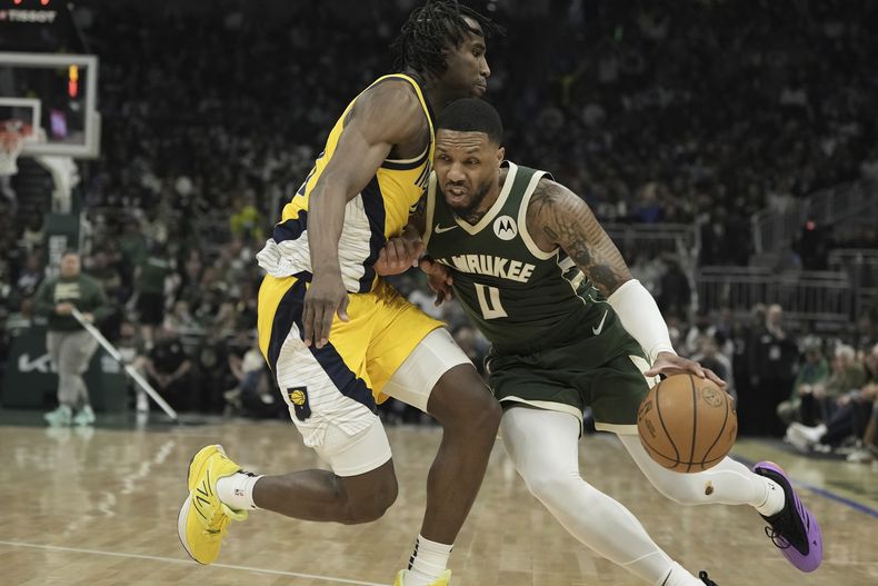 Damian Lillard, de los Bucks de Milwaukee, busca pasar a Aaron Nesmith, de los Pacers de Indiana, durante la primera mitad del Juego 1 de la serie de playoffs del baloncesto de la NBA, el domingo 21 de abril de 2024, en Milwaukee. (AP Foto/Morry Gash)