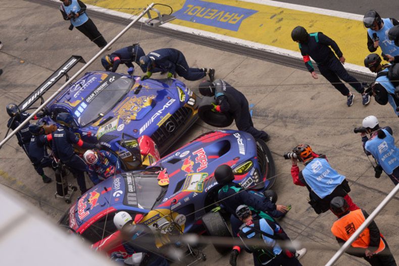 El equipo de mecánicos trabaja en el auto Mercedes AMG GT3 del líder Max Verstappen (derecha) mientras realiza una parada en pits al mismo tiempo que el Mercedes-AMG Team RAVENOL, que ocupa la segunda posición con los alemanes Maro Engel, Luca Stolz, Fabian Schiller y Maxime Martin, durante la carrera de automovilismo de las 24 Horas de Nürburgring en Nürburg, Alemania, el domingo 17 de mayo de 2026. (Thomas Frey/dpa vía AP)