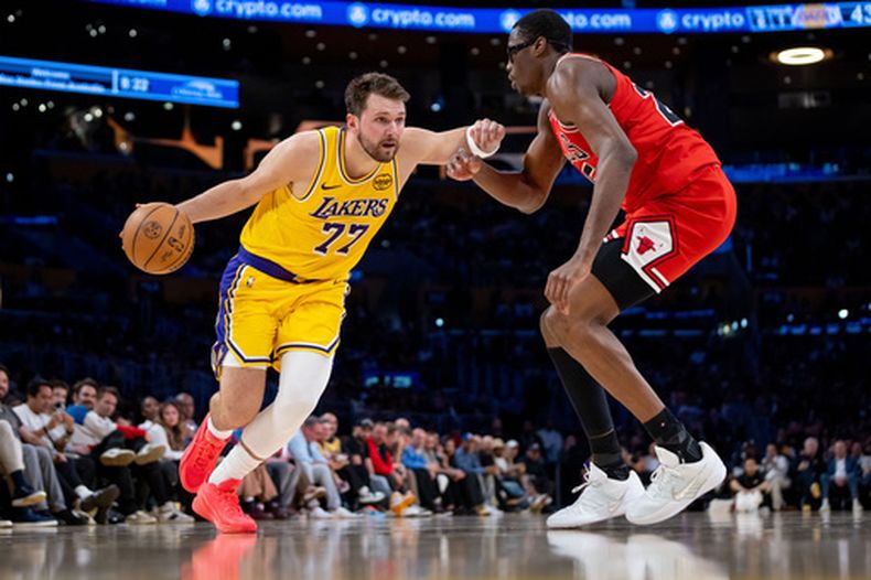 El esloveno Luka Doncic, de los Lakers de Los Ángeles, trata de avanzar ante Jalen Smith, en el encuentro del jueves 12 de marzo de 2026 (AP Foto/Ethan Swope)