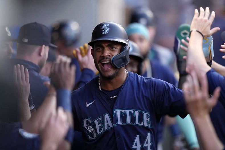 El dominicano Julio Rodríguez, de los Marineros de Seattle, festeja en la cueva luego de anotar en el juego del viernes 30 de agosto de 2024, ante los Angelinos de Los Ángeles (AP foto/Mark J. Terrill)