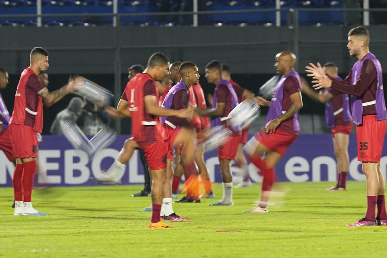 Jugadores del Athlético Paranaense calientan antes de un partido de la Copa Libertadores ante Libertad de Paraguay, el jueves 4 de mayo de 2023, en Asunción (AP Foto/Jorge Saenz)
