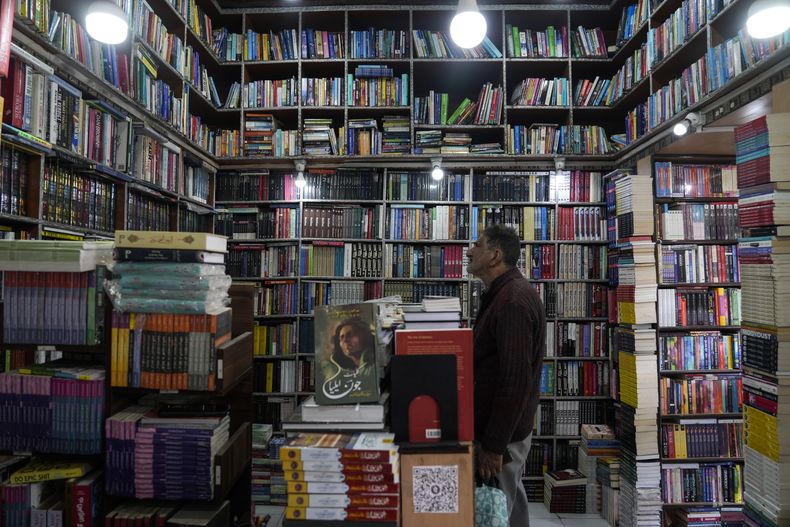 Un hombre cachemir mira dentro de una librería en Srinagar, en la Cachemira controlada por India, el lunes 17 de febrero de 2025. (AP Foto/Mukhtar Khan)