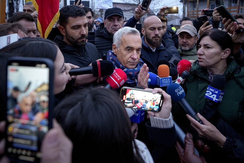 Calin Georgescu, centro, candidato presidencial independiente quien ganó la primera ronda de las elecciones, habla a la prensa afuera de un centro de votación en Mogosoaia, Rumania, el 8 de diciembre del 2024. (Foto AP/Andreea Alexandru)