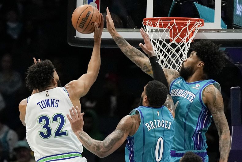 Nick Richards (derecha) de los Hornets de Charlotte tapa un disparo de Karl-Anthony Towns de los Timberwolves de Minnesota, el sábado 2 de diciembre de 2023, en Charlotte. (AP Foto/Chris Carlson)