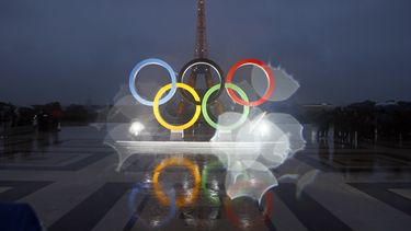 ARCHIVO - Esta foto que fue tomada con una lente con gotas de lluvia muestra los anillos olímpicos en la plaza Trocadero que observa la Torre Eiffel, luego de una votación en Lima, Perú, otorgando los Juegos de 2024 a la capital de Francia, París, el 13 de septiembre de 2017. (AP Foto/Francois Mori, Archivo)