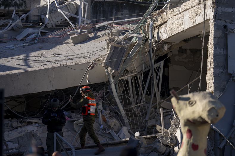 Un miembro de una unidad militar examina los daños causados por la caída de un gran trozo de metralla de un misil hutí, que derribó una escuela en Ramat Gan, un suburbio de Tel Aviv, Israel, el 19 de diciembre de 2024. (AP Foto/Ariel Schalit)