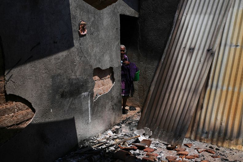 María Anastasia Cabrera camina por las ruinas de su casa después de que los ataques armados cometidos por grupos criminales locales obligaran a decenas de residentes a huir, en Tula, México, el viernes 15 de mayo de 2026. (AP Foto/Marco Ugarte)