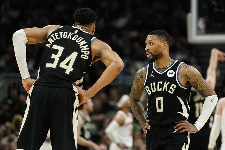 Damian Lillard (0), de los Bucks de Milwaukee, habla con Giannis Antetokounmpo (34) durante la primera mitad del juego de baloncesto de la NBA en contra de los Knicks de Nueva York, el domingo 7 de abril de 2024, en Milwaukee. Ni Lillard ni Antetokounmpo estarán disponibles para jugar contra el Thunder de Oklahoma City el viernes 12 de abril por la noche por lesión. (AP Foto/Aaron Gash)