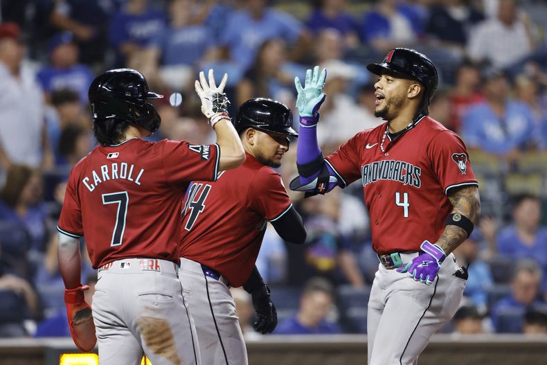 Ketel Marte (4), de los Diamondbacks de Arizona, celebra después de batear jonrón de tres carreras con Corbin Carroll (7) y Gabriel Moreno (14) durante la novena entrada del juego de béisbol contra los Reales de Kansas City, en Kansas City, Missouri, el miércoels 24 de julio de 2024. (AP Foto/Colin E. Braley)