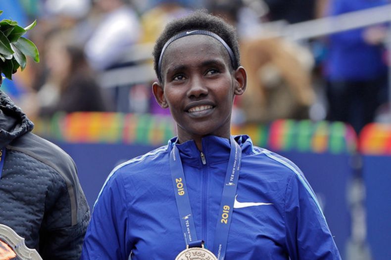 ARCHIVO - Foto del 3 de noviembre del 2019, la etiope Ruti Aga en el podio tras terminar tercera en el Maratón de Nueva York. (AP Foto/Richard Drew, Archivo)