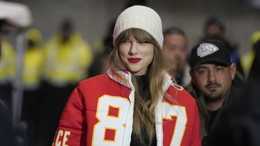 ARCHIVO - Taylor Swift lleva un abrigo con el número del tight end de Kansas CityTravis Kelce diseñada por Kristin Juszczyk, antes de llegar a un partido de postemporada de la NFL entre los Chiefs y los Dolphins de Miami el 13 de enero de 2024, en Kansas City, Missouri. (Foto AP/Ed Zurga, archivo)