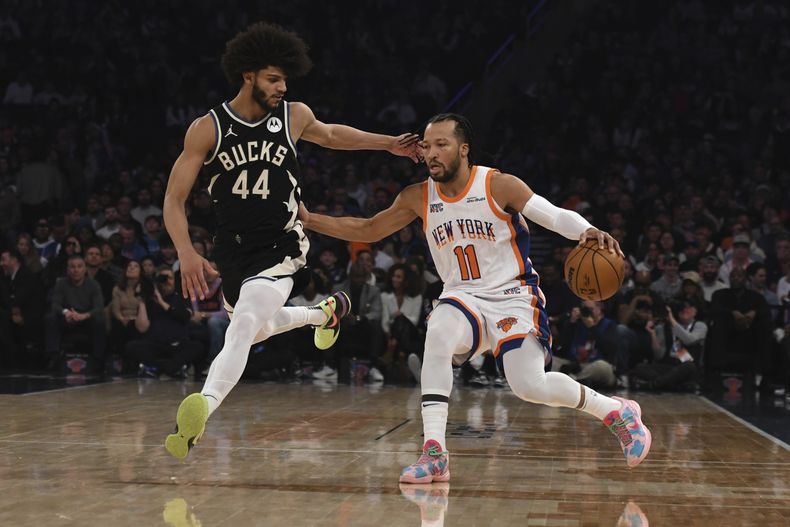 Jalen Brunson, derecha, de los Knicks de Nueva York, conduce el balón ante la presión defensiva de Andre Jackson Jr., izquierda, de los Bucks de Milwaukee, durante la primera mitad del juego de baloncesto de la NBA, el domingo 12 de enero de 2025, en Nueva York. (AP Foto/Pamela Smith)
