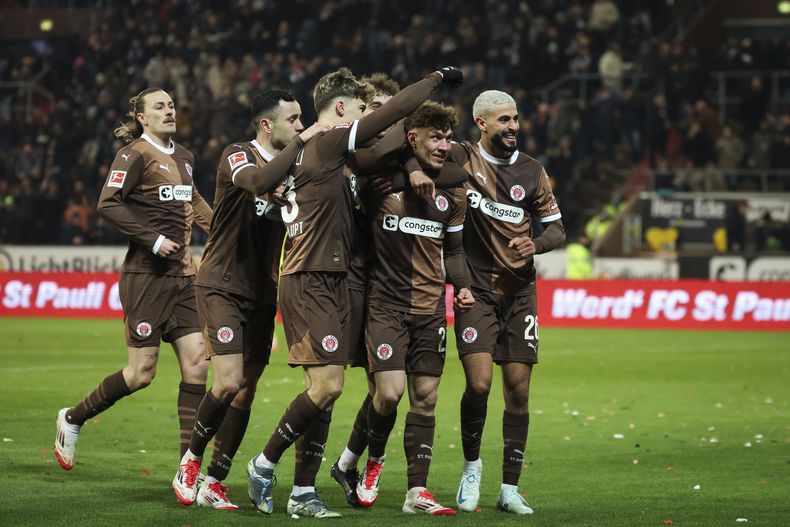 Noah Weisshaupt del St. Pauli celebra con sus compañeros tras abrir el marcador en el encuentro ante el Hoffenheim de la Bundesliga el viernes 14 de marzo del 2025. (Christian Charisius/dpa via AP)