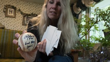 TeriAnn Reynolds sostiene una pelota autografiada por el pelotero colombiano Donovan Solano, el jueves 27 de abril de 2023, en Johnson City, Tennessee (AP Foto/George Walker IV)