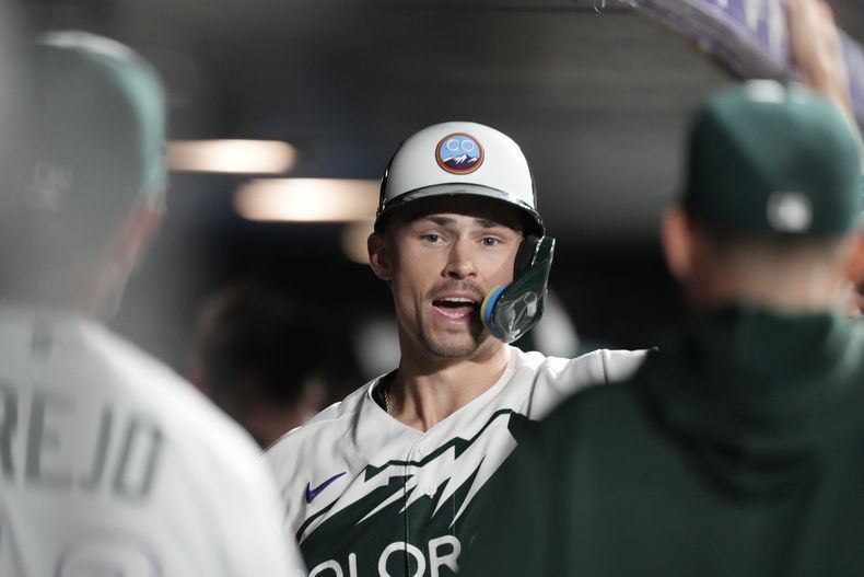 Brenton Doyle, de los Rockies de Colorado, festeja en la cueva luego de pegar un triple de tres carreras ante los Azulejos de Toronto, el sábado 2 de septiembre de 2023 (AP Foto/David Zalubowski)