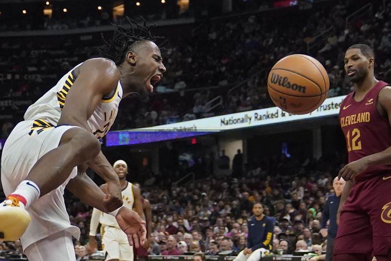 Aaron Nesmith, alero de los Pacers de Indiana, festeja luego de lograr una volcada frente a Tristan Thompson, de los Cavaliers de Cleveland, en el partido del sábado 28 de octubre de 2023 (AP foto/Sue Ogrocki)