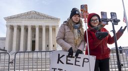 Sarah Baus, a la izquierda, de Charleston, Carolina del Sur, y Tiffany Cianci, quien dice ser una creadora de contenido educativo de formato largo, transmiten en vivo a TikTok fuera de la Corte Suprema, el viernes 10 de enero de 2025, en Washington. (AP Foto/Jacquelyn Martin)