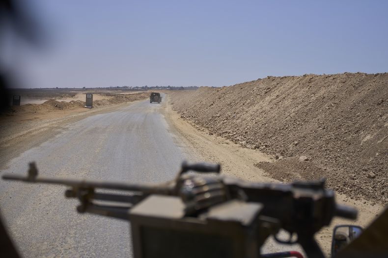 Vehículos del ejército israelí transportan a un grupo de soldados y periodistas por el corredor de Morag, en el sur de Gaza, el 8 de junio de 2025. El ejército israelí invitó a reporteros a un recorrido por el Hospital Europeo en Jan Yunis. (AP Foto/Ohad Zwigenberg)