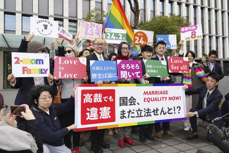 Demandantes y sus partidarios celebran el fallo de un alto tribunal japonés que declaró que la negativa del país a reconocer el matrimonio entre personas del mismo sexo en inconstitucional, en el exterior de la Corte Suprema de Fukuoka, en Fukuoka, en el sur de Japón, el 13 de diciembre de 2024. (Kyodo News vía AP)