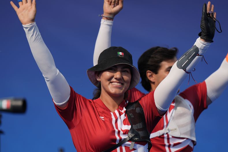 Alejandra Valencia, a la izquierda, y Matás Grande, de México celebran su victoria sobre Brasil en la ronda eliminatoria del tiro con arco en la prueba por equipos mixtos el viernes 2 de agosto de 2024, en París, Francia. (AP Foto/Brynn Anderson)