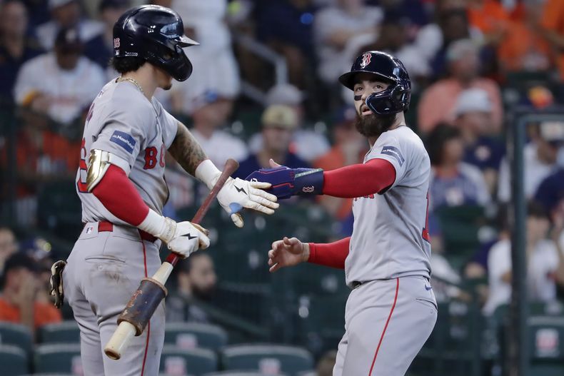 Jarren Duran y Connor Wang celebran después de que anotaron con el doble remolcador de Ceddanne Rafaela de los Medias Rojas de Boston en la segunda entrada ante los Astros de Houston el miércoles 21 de agosto del 2024. (AP Foto/Michael Wyke)