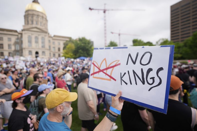 Un manifestante sostiene un cartel en una protesta bajo el lema No Kings (“Sin reyes”), el sábado 14 de junio de 2025 en Atlanta. (AP Foto/Mike Stewart)