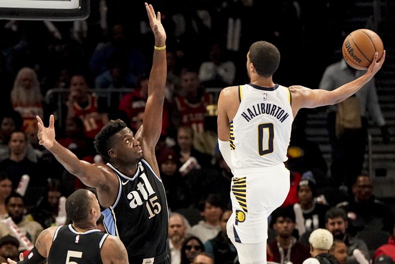 Tyrese Haliburton, base de los Pacers de Indiana, dispara frente a Clint Capela, pívot de los Hawks de Atlanta, en el encuentro del martes 21 de noviembre de 2023 (AP Foto/Mike Stewart)