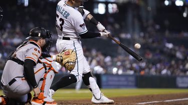 Christian Walker, de los Diamondbacks de Arizona, batea un doblete frente al receptor de los Gigantes de San Francisco Patrick Bailey durante la séptima entrada del juego de béisbol del miércoles 20 de septiembre de 2023, en Phoenix. Los Diamondbacks ganaron 7-1. (AP Foto/Ross D. Franklin)