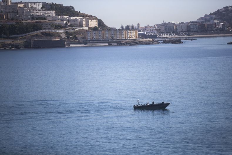 ARCHIVO - Un barco de la marina marroquí trata de interceptar a un chico que nada hacia el enclave español de Ceuta, en la frontera entre Marruecos y España, el 19 de mayo de 2021. (AP Foto/Mosaab Elshamy, Asunto)