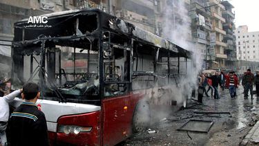 americateve | Esta imagen cedida por el Centro de Medios de Alepo ha sido autentificada sobre la base de su contenido y otra informaci&oacute;n de la AP muestra a varias personas observando un autob&uacute;s calcinado tras ser blanco de un cohete lanzado por un avi&oac